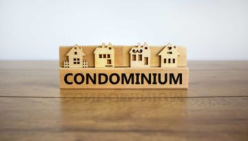 Block form the word condominium in front of a miniature house