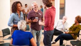 Group Of People Socializing After Meeting In Community Center