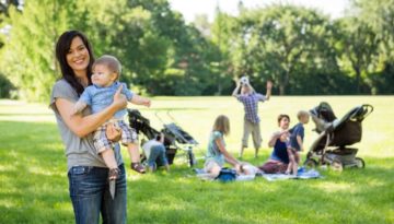 Happy Mother Carrying Baby Boy At Park (R) (S)