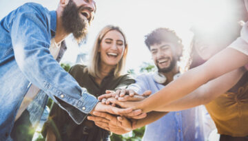 Multiracial happy young people stacking hands on top of each other - Diverse friends unity togetherness in volunteer community - Concept about college, relationship, youth and human resources