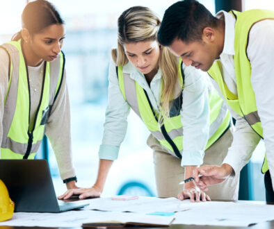 Architect, team and meeting in blueprint planning for construction, architecture or project collaboration. Group of contractors discussing floor plan or teamwork strategy for industrial architecture