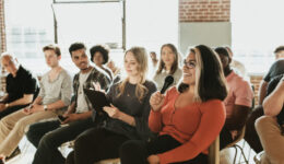 Cheerful woman speaking on a microphone in a workshop