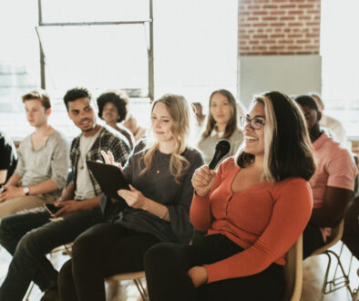 Cheerful woman speaking on a microphone in a workshop