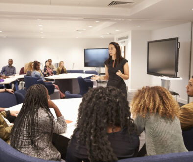 Female teacher addressing university students in a classroom