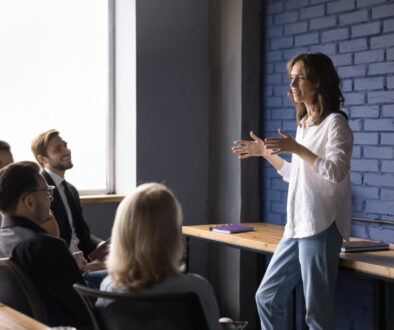 Young woman leader explains work tasks to company employees